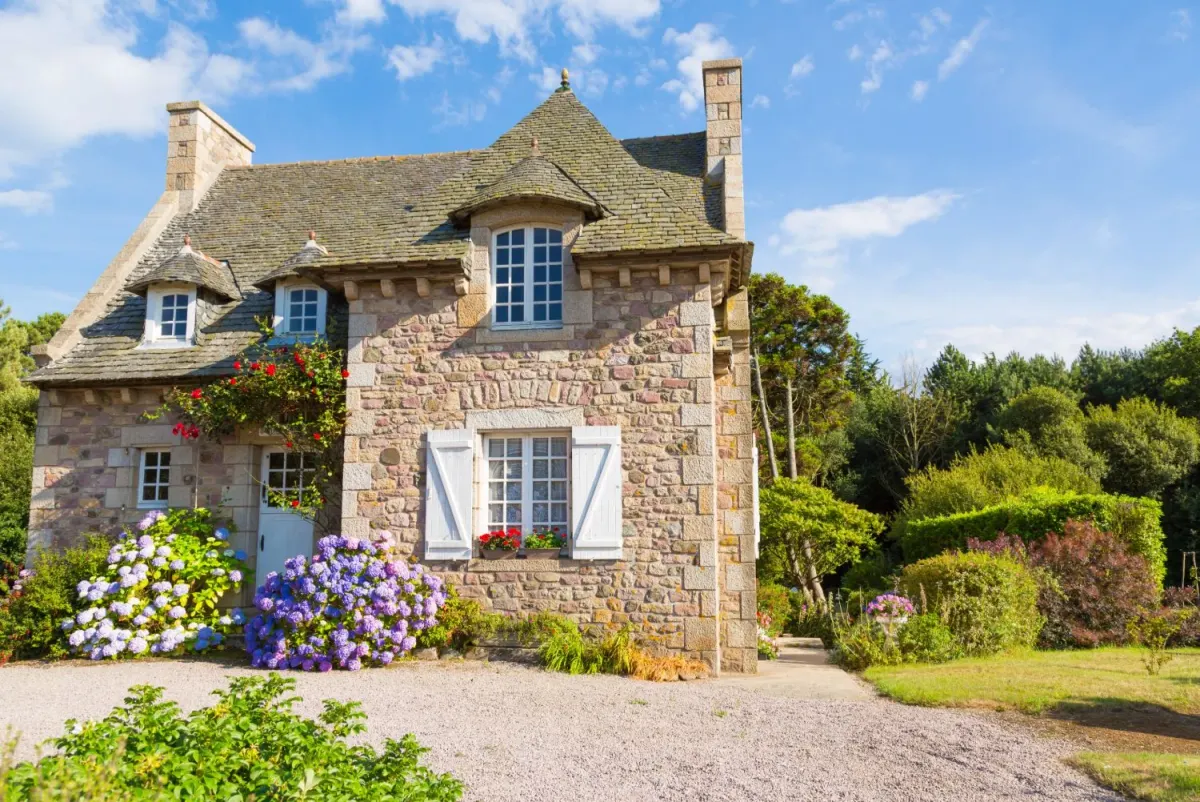 Maison bretonne en pierre avec ses menuiseries blanches et ses hortensias