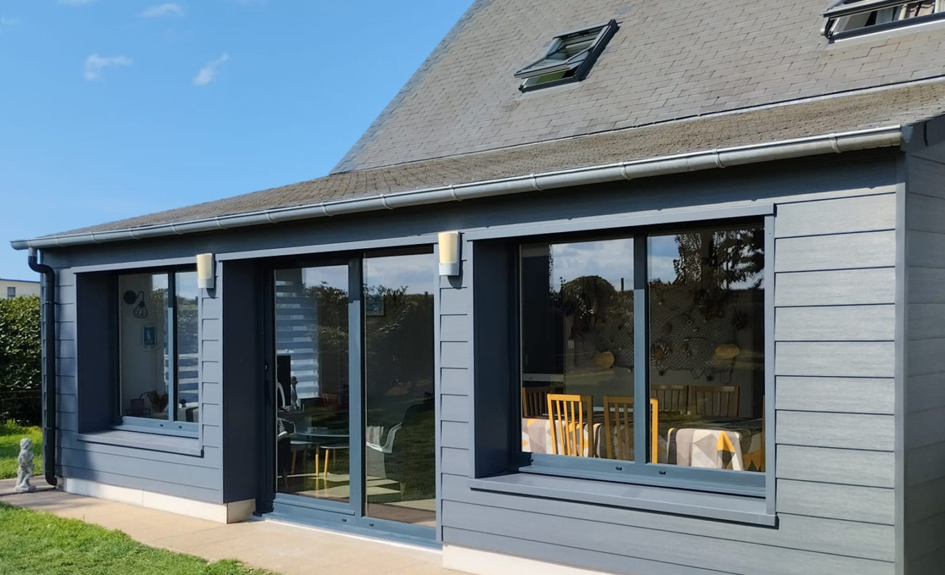 Extension de maison avec grandes fenêtres et porte-fenêtre