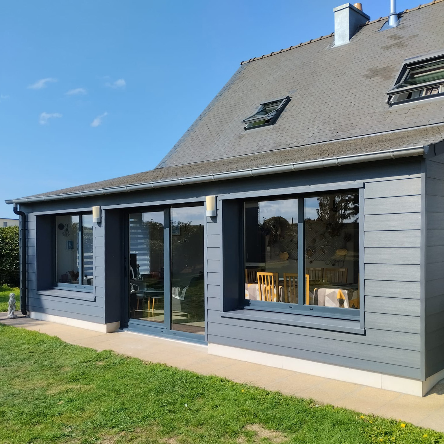 Extension de maison avec grandes fenêtres et porte-fenêtre