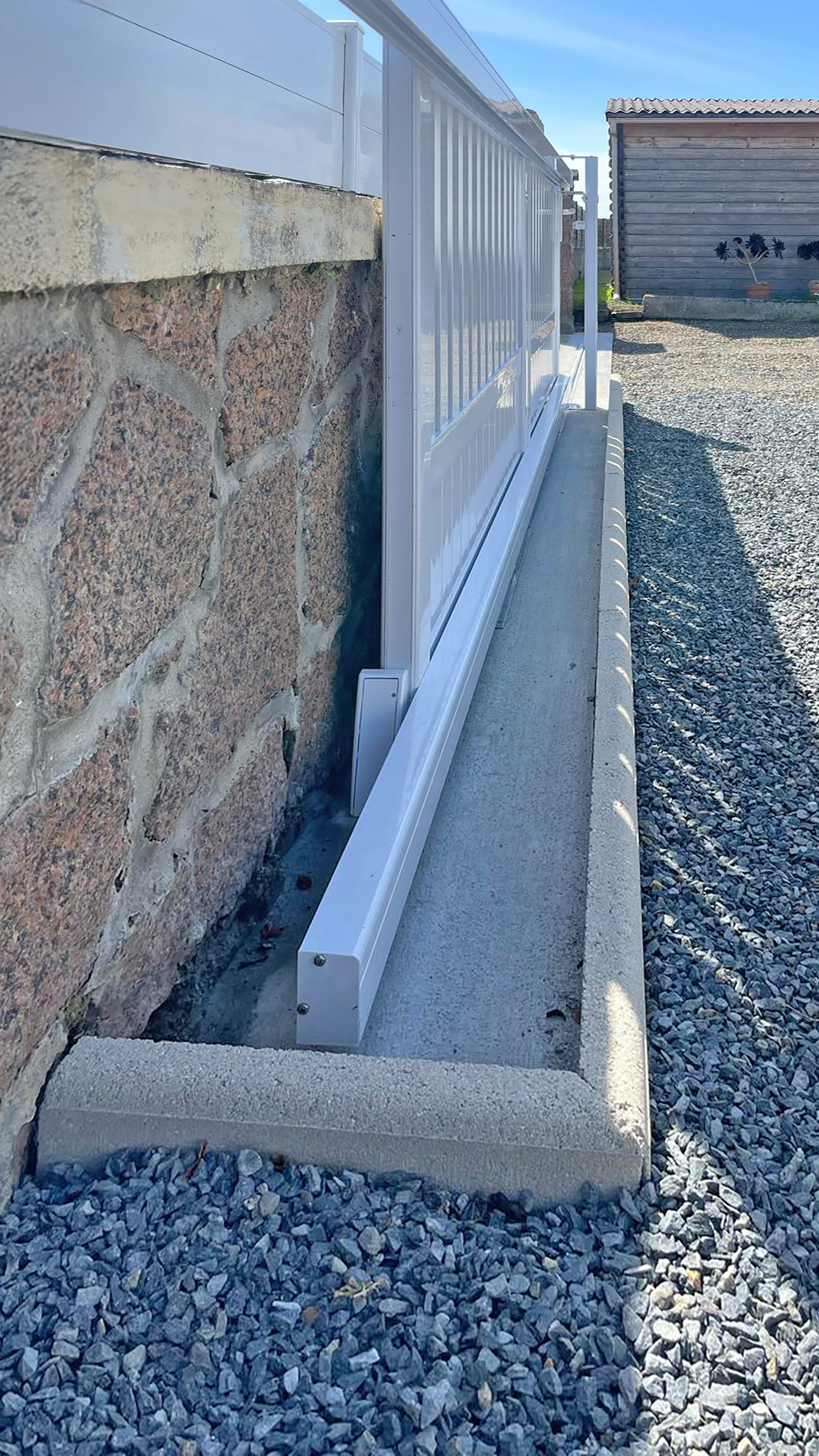 focus sur le systeme coulissant d'un portail kiclos en plv blanc