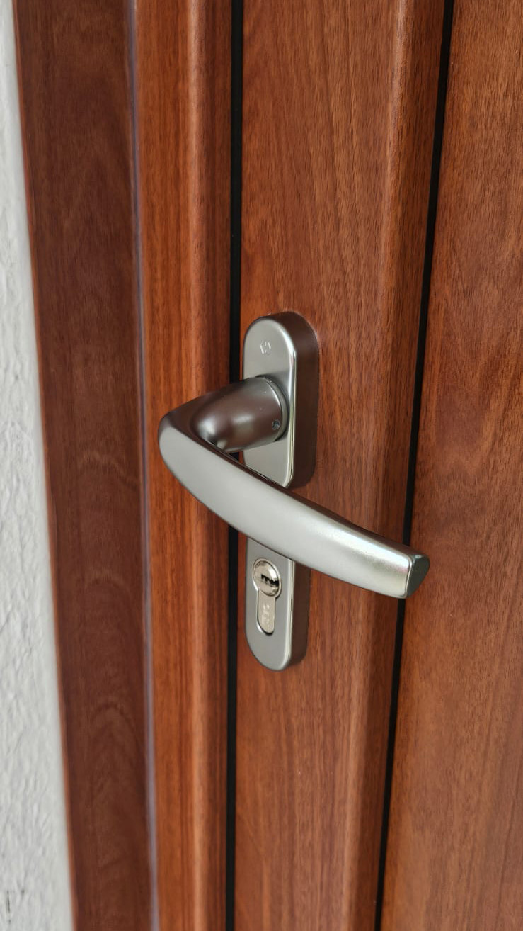 porte d'entree en plaxe noyer fonce focus sur la poignee