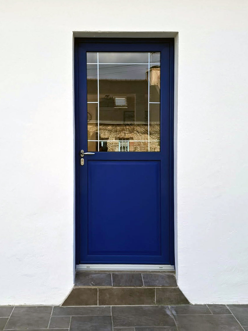 porte d'entree en pvc bleu a l'exterieur avec soubassement port-forme avec petit bois en plomb